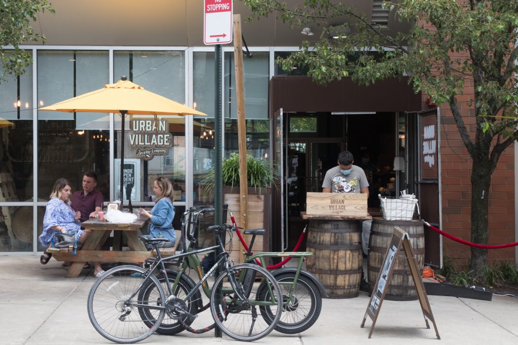 people dining outdoors at a pinic table outside a restaurant