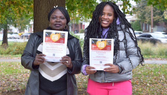 Grace and Queen holding up the "Love Your Park" flyers.