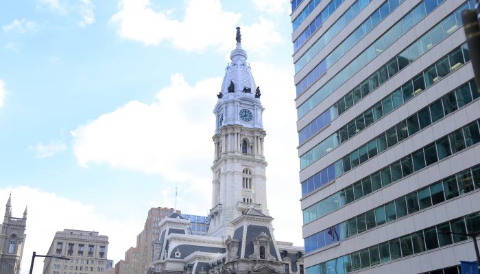 View of City Hall from the ground during the day. A blue sky is in the background.