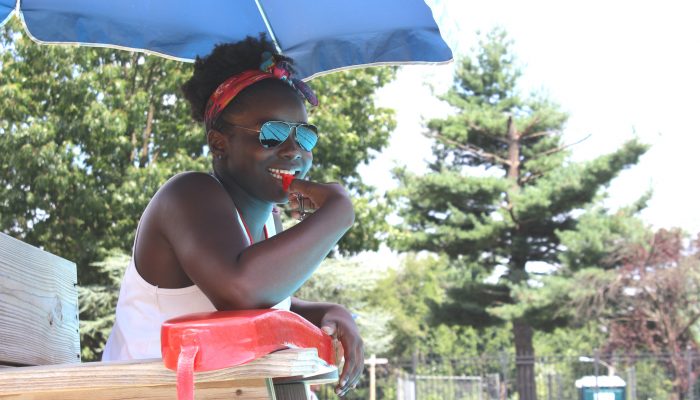 Lifeguard blowing whistle and smiling