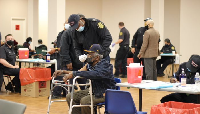 a philadelphia fire department employee vaccinating a philadelphia resident