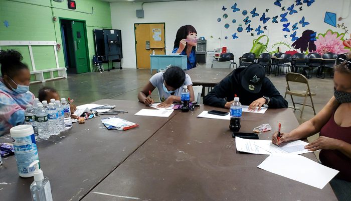 Workshop participants sitting around a table completing forms