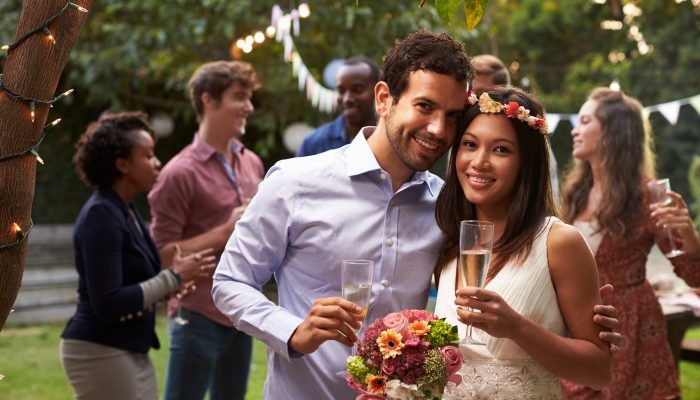 Two people celebrating their wedding with friends outdoors