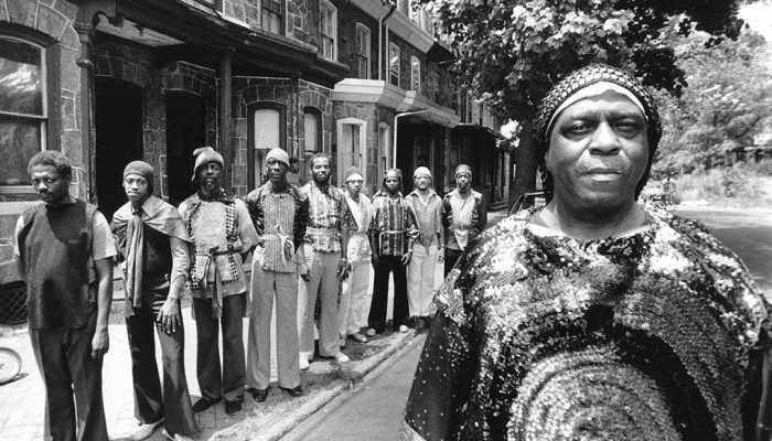 A photo of Sun Ra and his Arkestra in front of 5626 Morton Street in the 1970s.