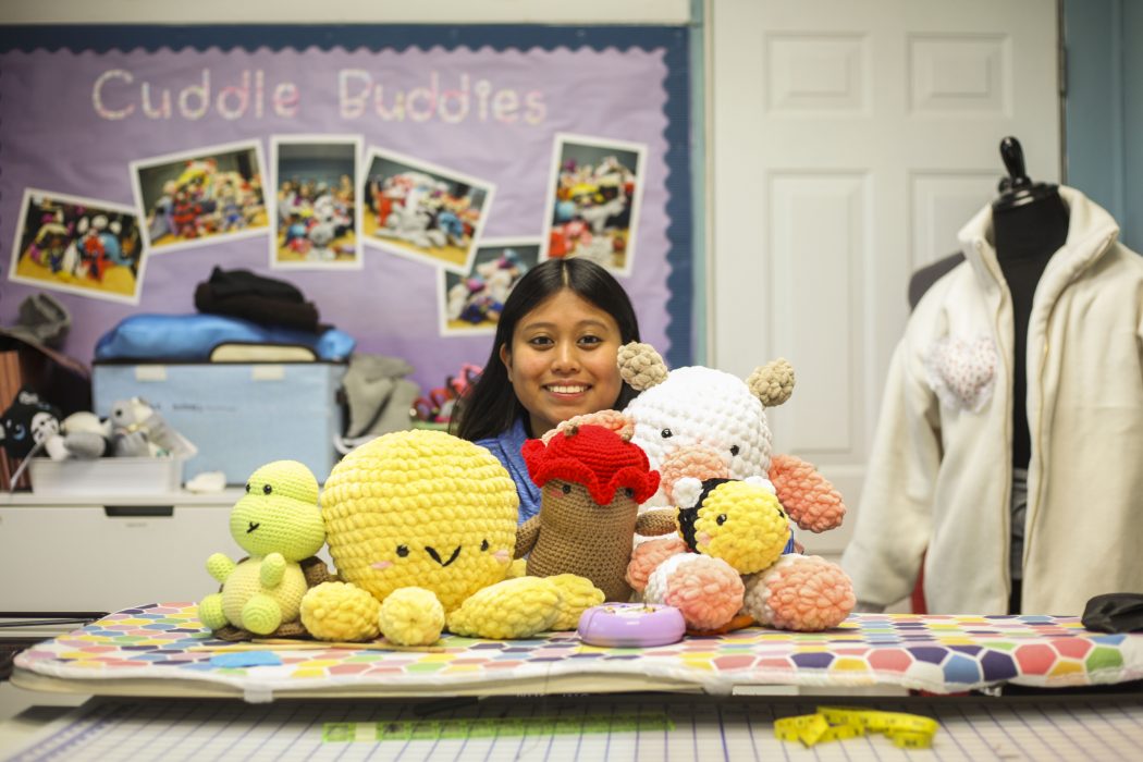Kira poses with her crocheted creations in The Crefeld School’s sewing room.