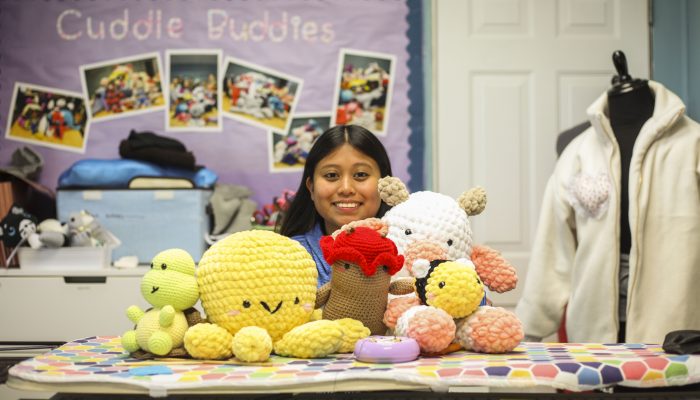 Kira poses with her crocheted creations in The Crefeld School’s sewing room.