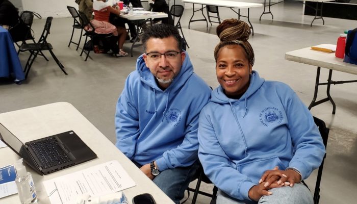 Dos asistentes sociales de la Oficina de Servicios para Personas sin Hogar sentados frente a una mesa