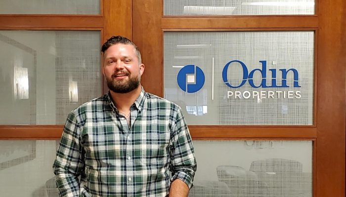 Jackson Duncan poses for a picture in front of Odin Properties' office