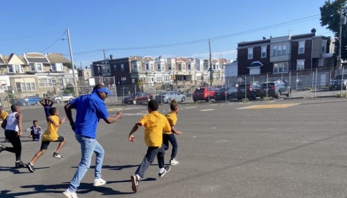 Man and Children running in school yard