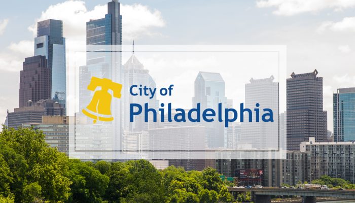 The city of philadelphia logo overlaid on a photo of the philadelphia skyline