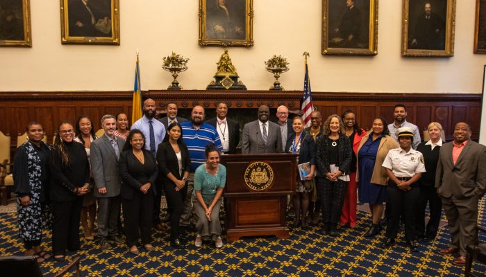 City employees in City Hall in front of podium