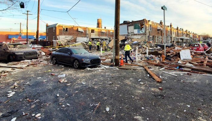 the scene on the 3500 block of Miller street with debris and rubble in the street and emergency workers assessing the site.