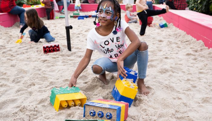 An African-American girl plays in the sand at the Fairmount Horticulture Center.