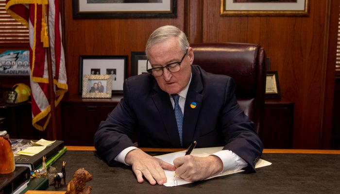 Mayor Jim Kenney signs the 17-111 executive order at his desk.