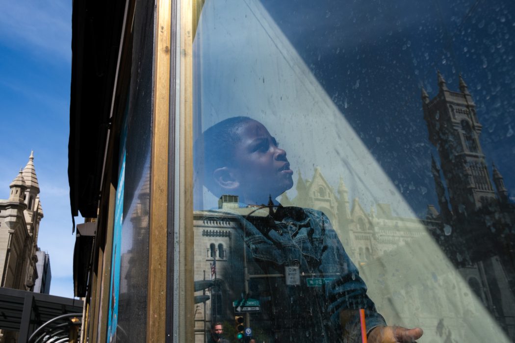 Young child's image reflected in the window of a building in center city Philadelphia.