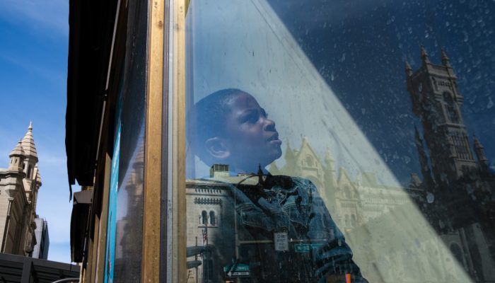 Young child's image reflected in the window of a building in center city Philadelphia.