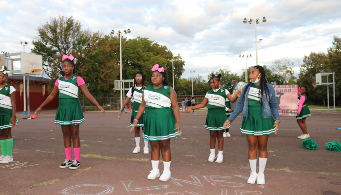 Children cheerleading in a neighborhood park