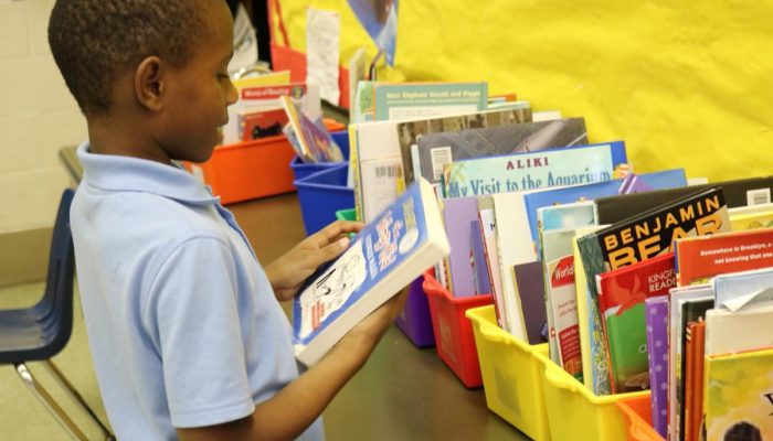 Child grabbing a book from shelf