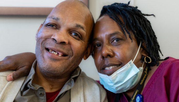 An older man and a nurse pose for a picture