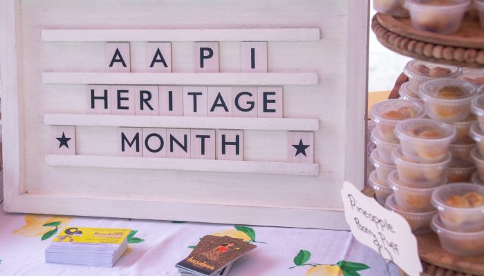 AAPI Heritage Month board on table in China Town open air market. 