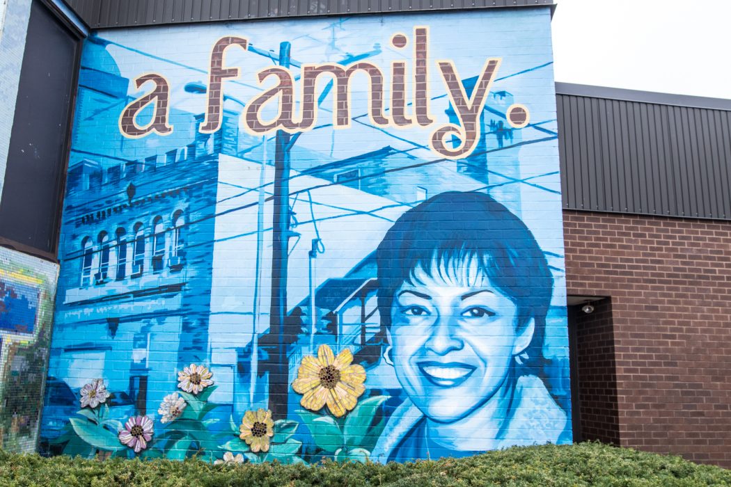 A mural of a woman and flowers with the words "a family."