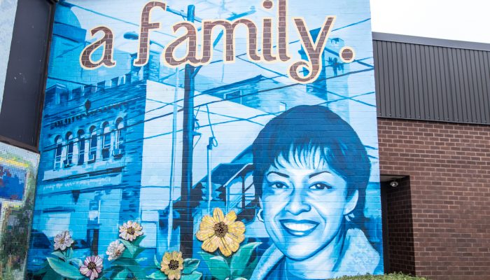 A mural of a woman and flowers with the words "a family."