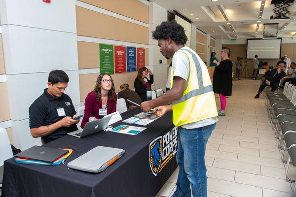 Guests chat with project teams at their project display table. 