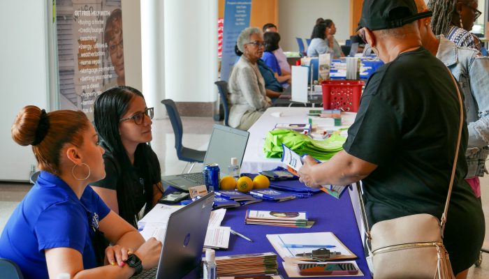 Les résidents explorent la table de l'Agence de coordination de l'énergie lors du salon de l'énergie de North Philly en avril 2023.