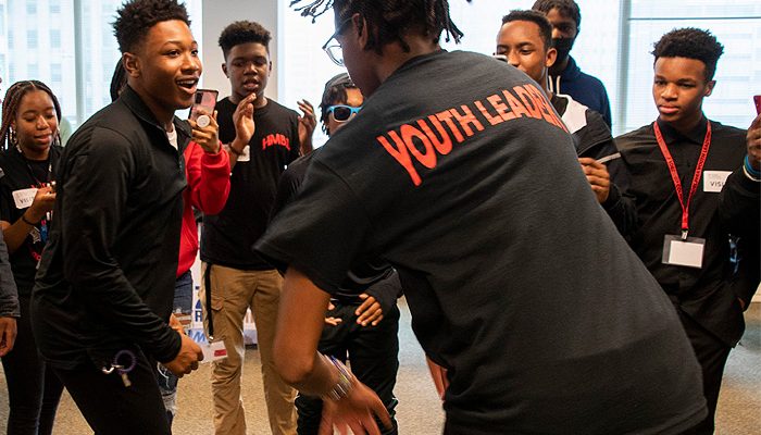 A youth leader runs an activity with a group of teens at a youth development program.