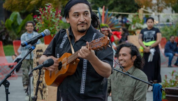 A Hispanic man plays a small guitar in Love Park in Philadelphia.