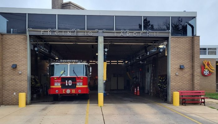 fire engine in garage with empty bay next to it under sign that says ladder 11