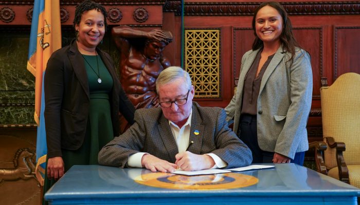 DEI employees stand behind Mayor Kenney as he signs executive order