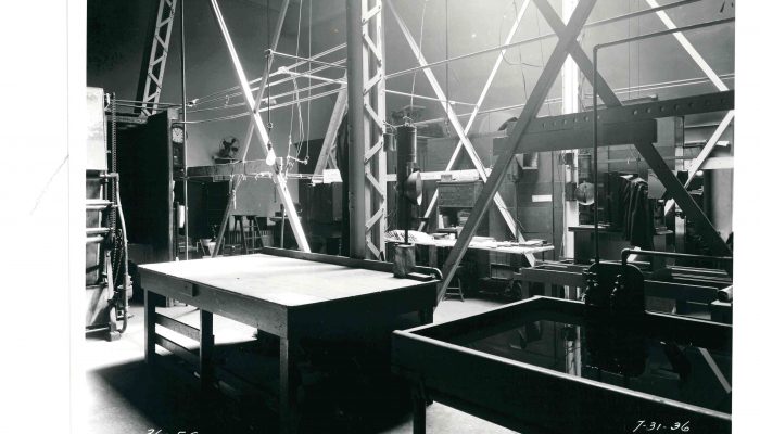 a black and white photograph dipicting a large room with tables and equipment for developing film