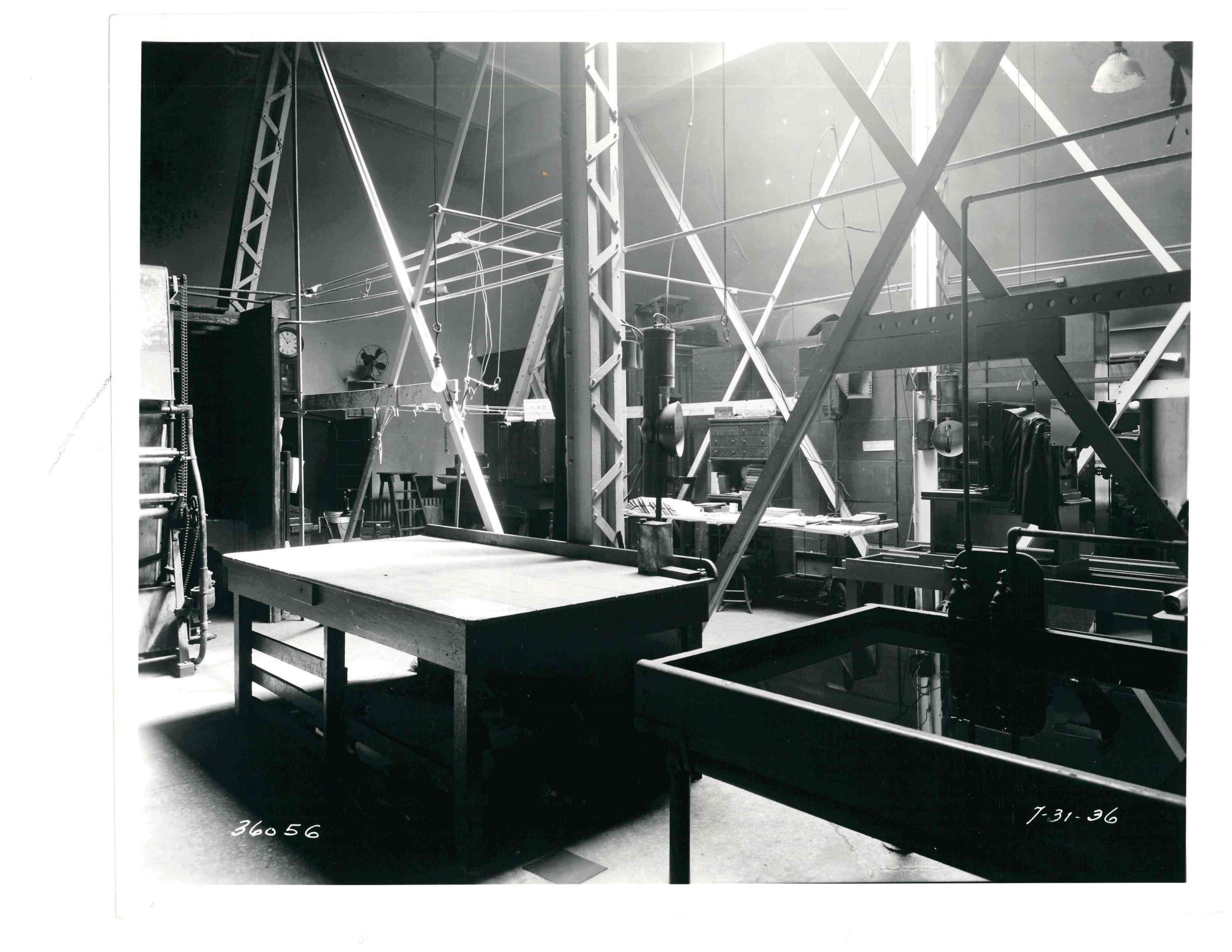 a black and white photograph dipicting a large room with tables and equipment for developing film