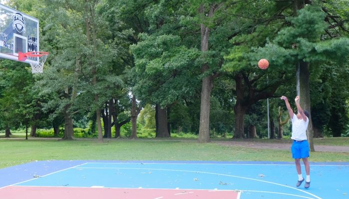 A youth throws a basketball at a basketball hoop. The basketball court at Fernhill Park was recently renovated. 