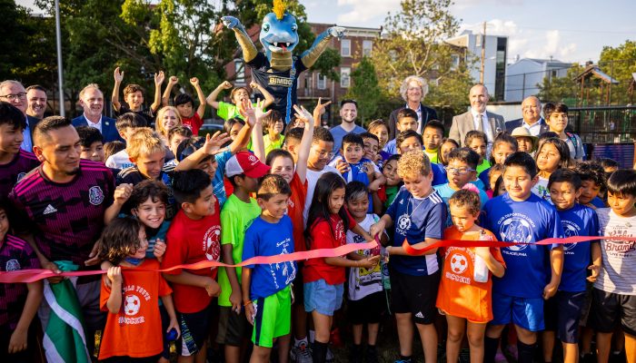 O prefeito Kenney, Phang e membros da comunidade cortaram uma fita para o Capitolo Playground