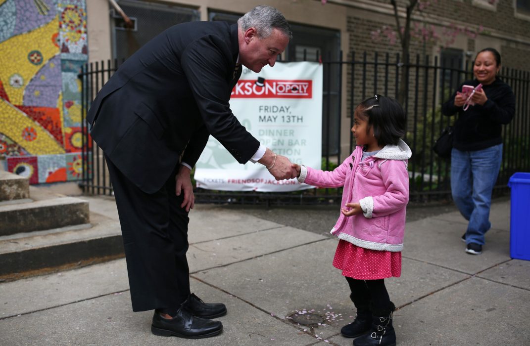 Mayor Kenney shaking hands with a young child