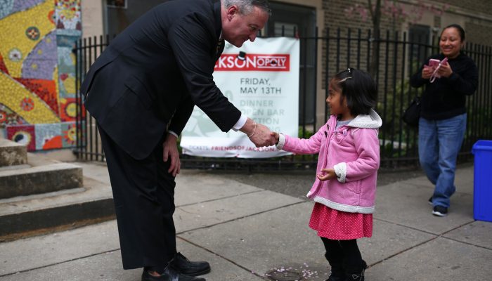 Mayor Kenney shaking hands with a young child