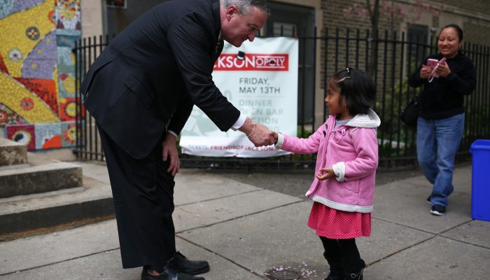 Alcalde/Alcaldesa Kenney estrechando la mano de un niño