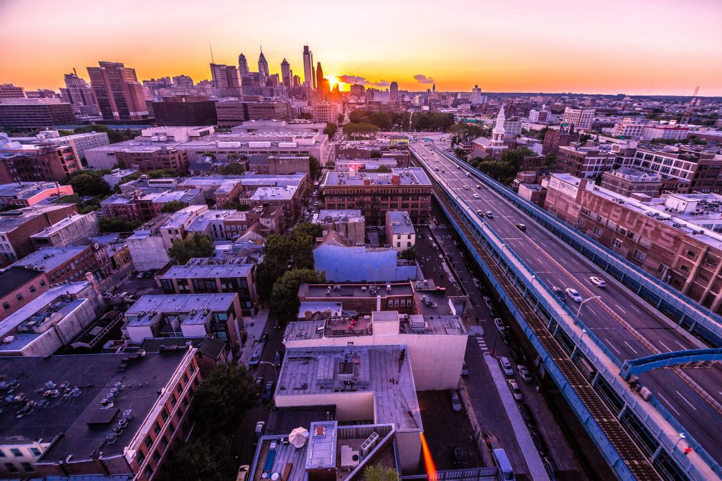 Philadelphia skyline in the distance, with the sun setting behind it