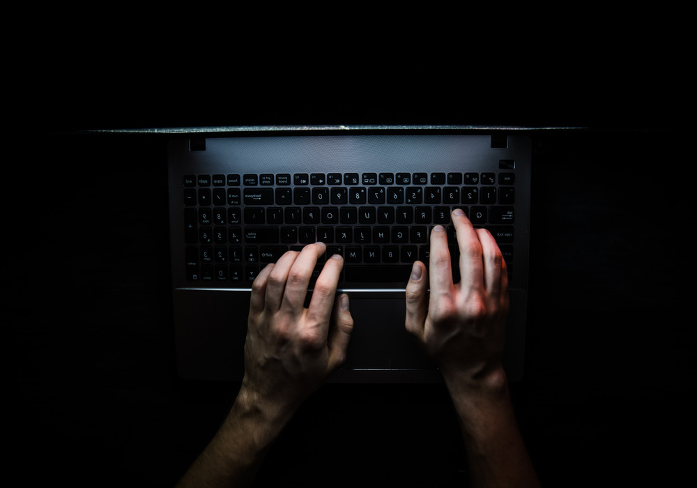 Hands typing on a computer keyboard