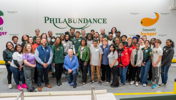 un groupe de bénévoles souriants pose devant le panneau Philabundance