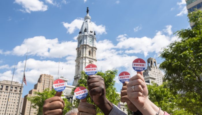 Thumbs holding "I voted" stickers