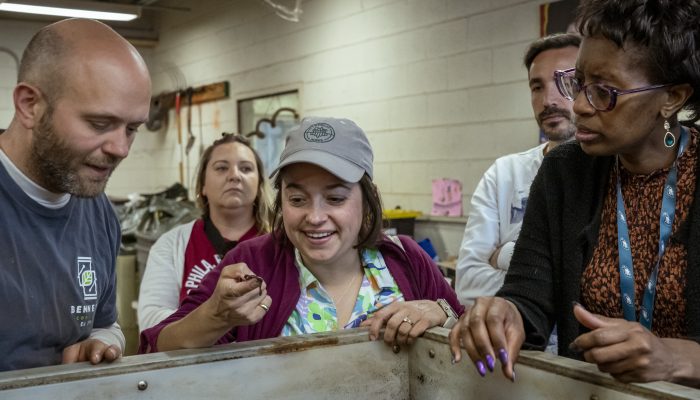 Katie, a Philadelphia Parks & Recreation employee, looks at a worm from the vermicompost at Bennett Compost facility in northeast Philadelphia.
