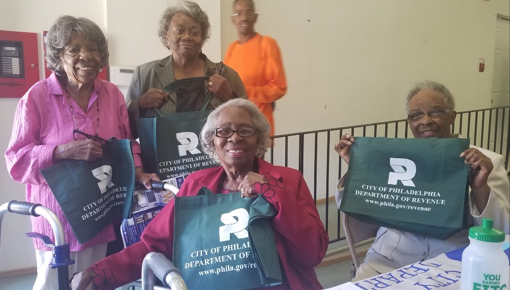 Smiling seniors hold Revenue swags