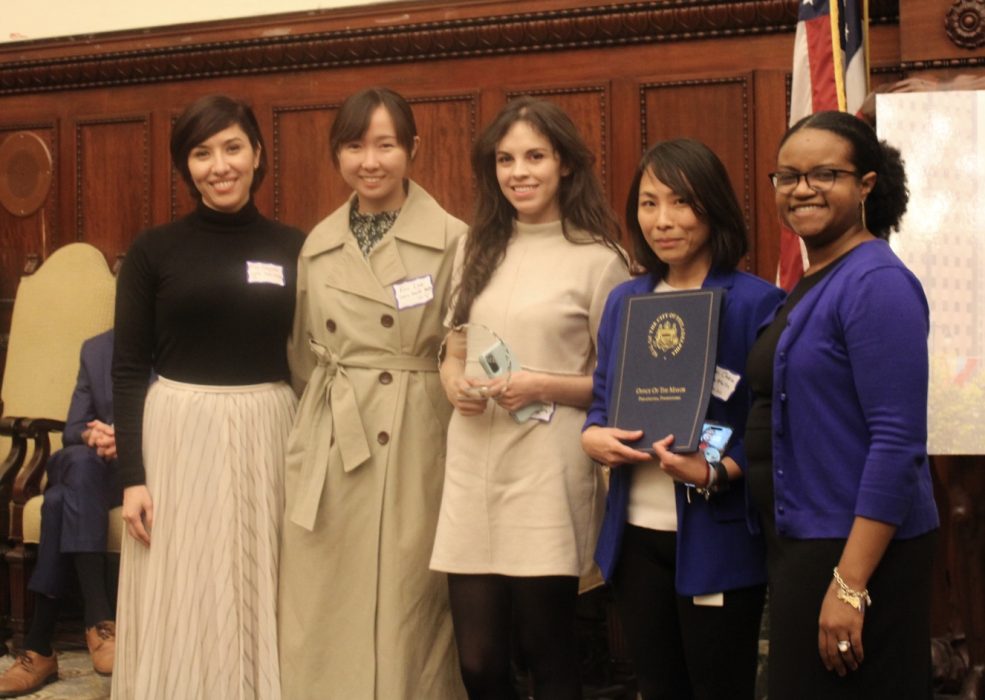 City official poses for photo with winners of Welcoming Awards