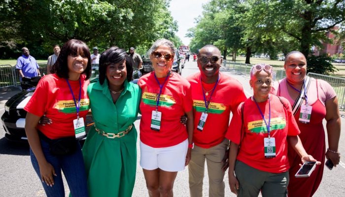 Mayor Parker standing with a group of people wearing Juneteenth shirts