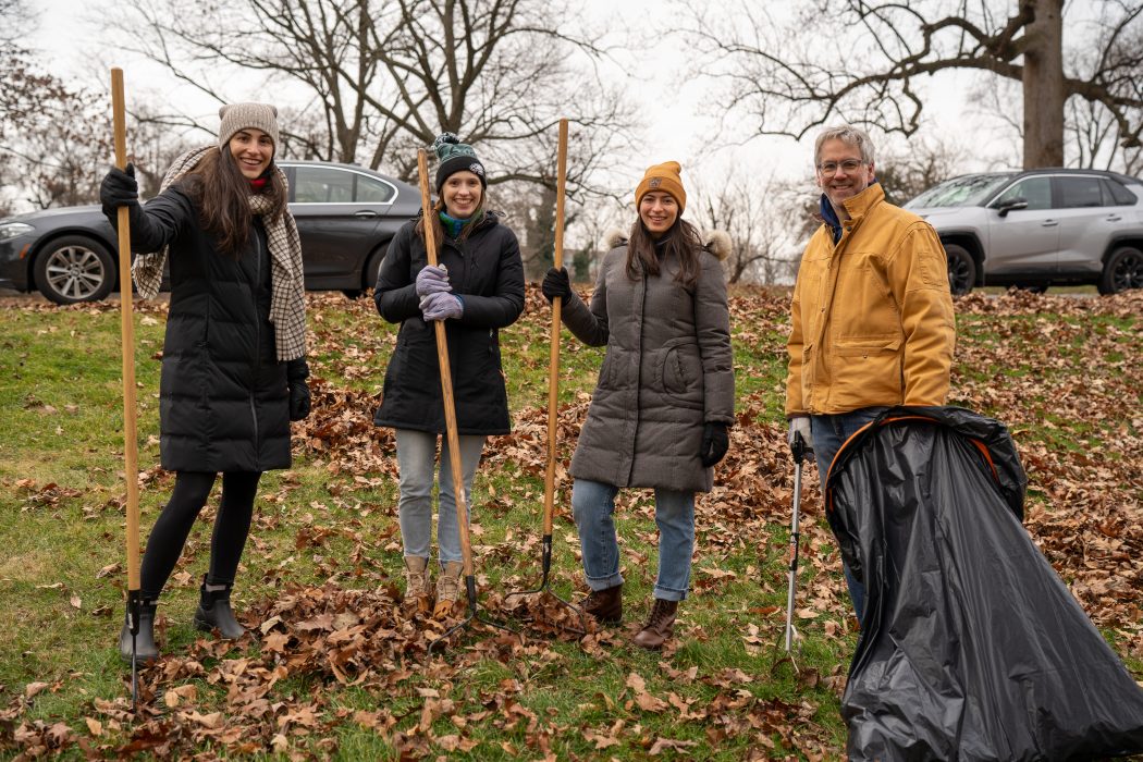 Volunteers pose with gardening tools.
