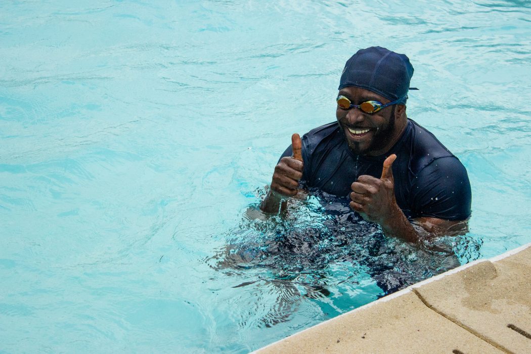 A man gives a thumbs up in a swimming pool.