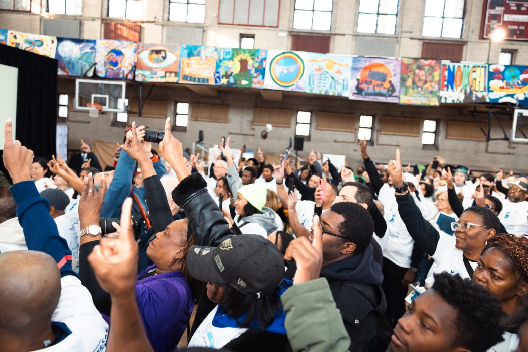 Attendees at the MLK Day of Service at Girard College put their hands in the air, pointing to the ceiling to signify "One Philadelphia"